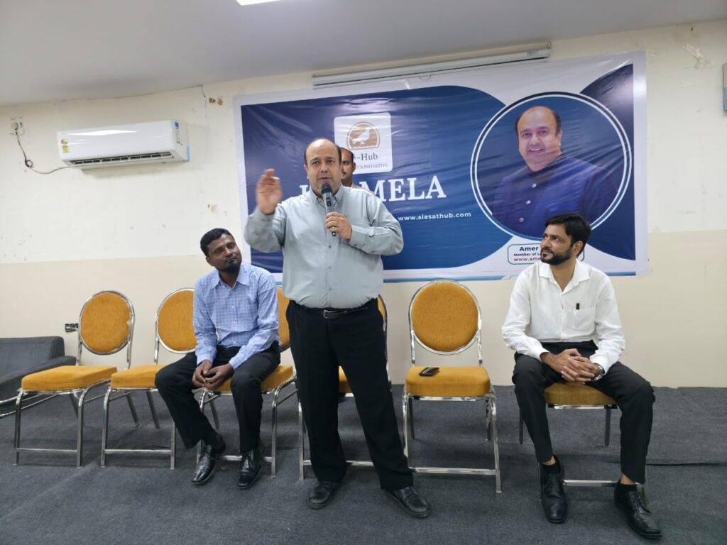 A man is speaking at a conference with three other men.