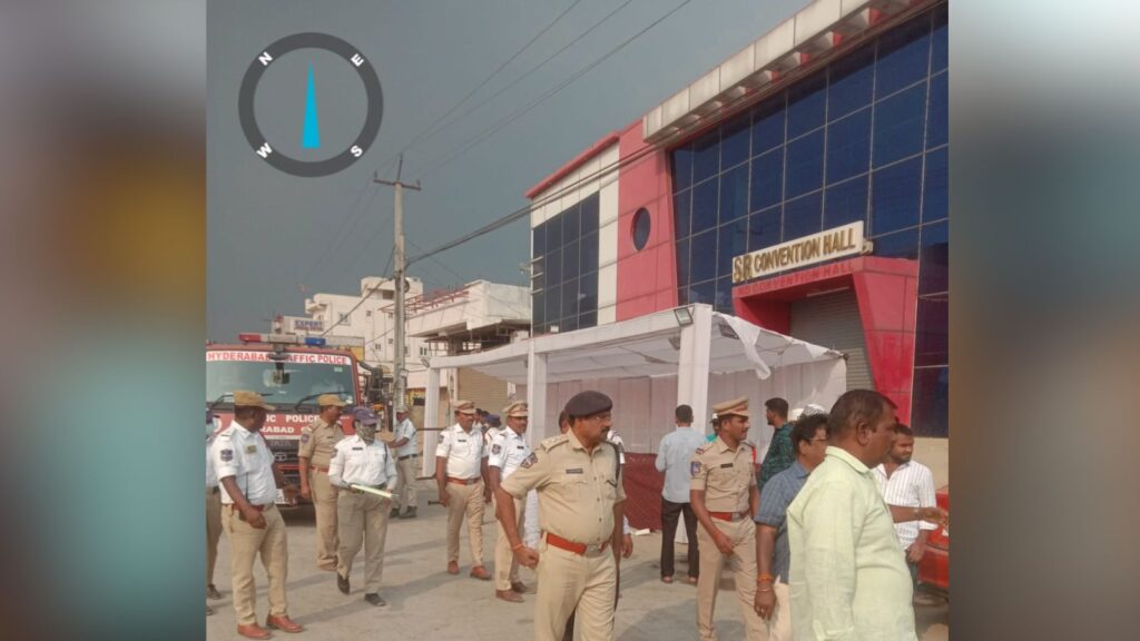 Emergency responders at a disaster site near a modern building with a sign reading "Construction Hall".