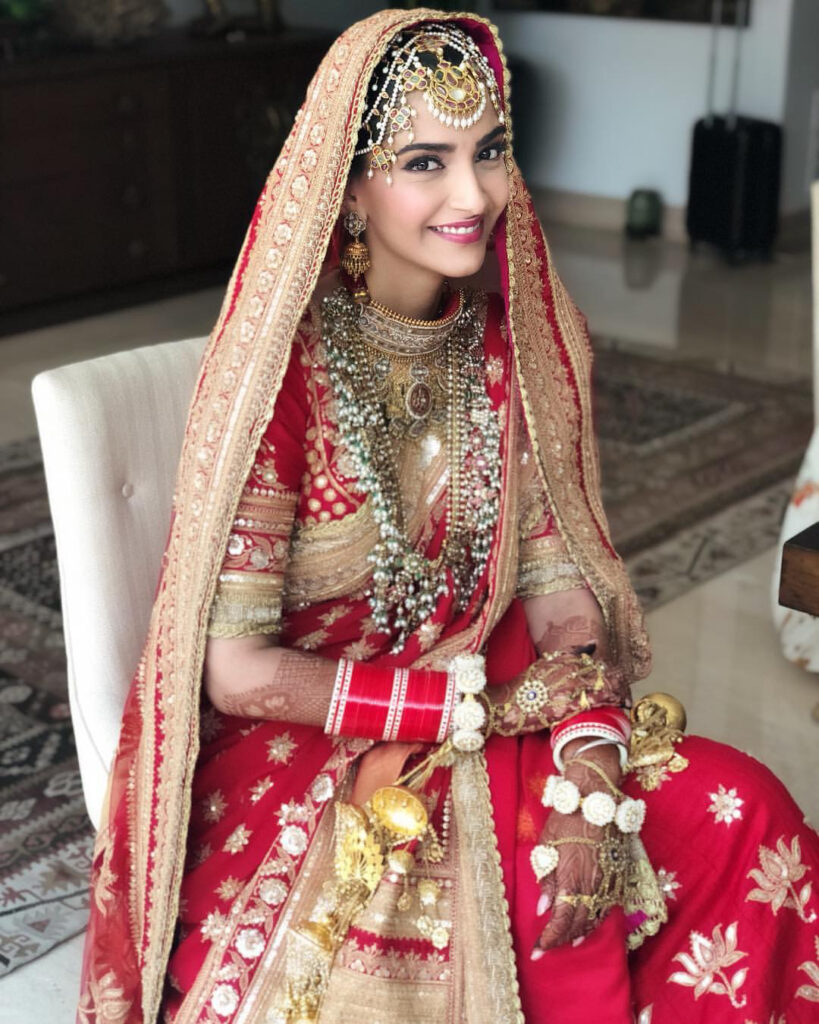 Elegant bridal outfit worn by Bollywood actress, featuring detailed embroidery and accessories.