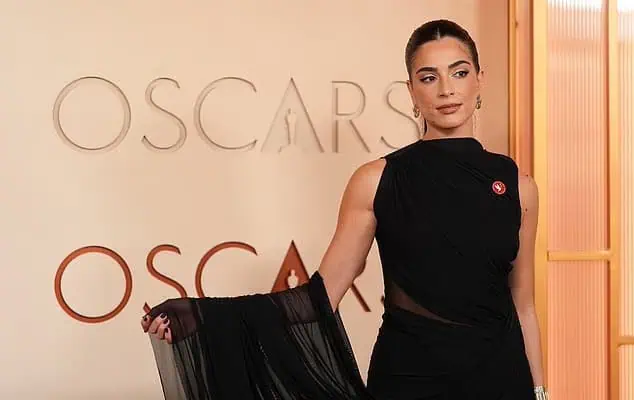 Saja Kilani wearing an Artists4Ceasefire pin on her black gown at the 2026 Oscars.