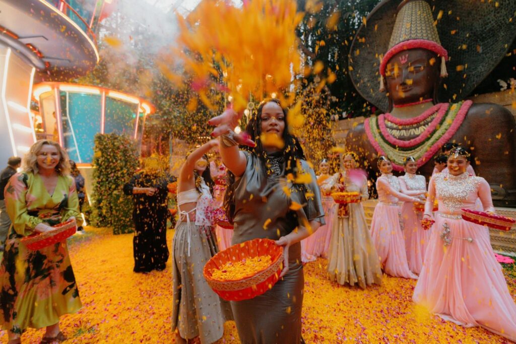 A woman throws flower petals during a vibrant Indian festival celebration with traditional costumes and c.