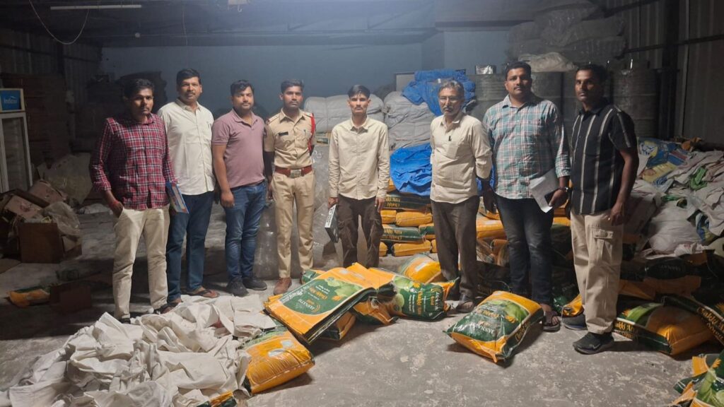 Group of men standing in a warehouse with waste bags and materials.