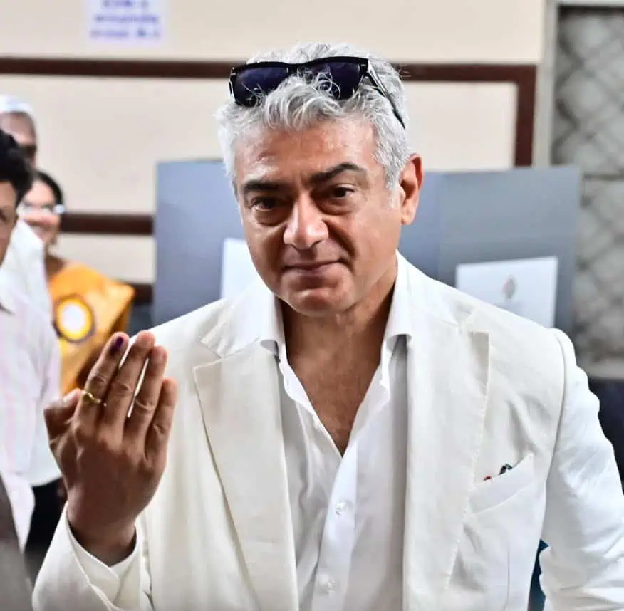 Man and woman in discussion surrounded by police and media personnel at an indoor event.