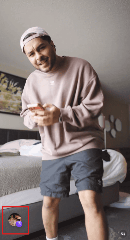 Hania Aamir smiling and using her phone, casual outfit, relaxed indoor setting.