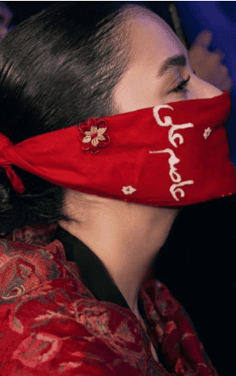 Hania Aamir wearing a red face mask with floral details, highlighting her style and personality.