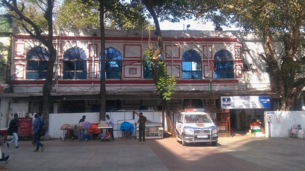 The Siasat Daily building with blue arched windows and street scene in Hyderabad, India.