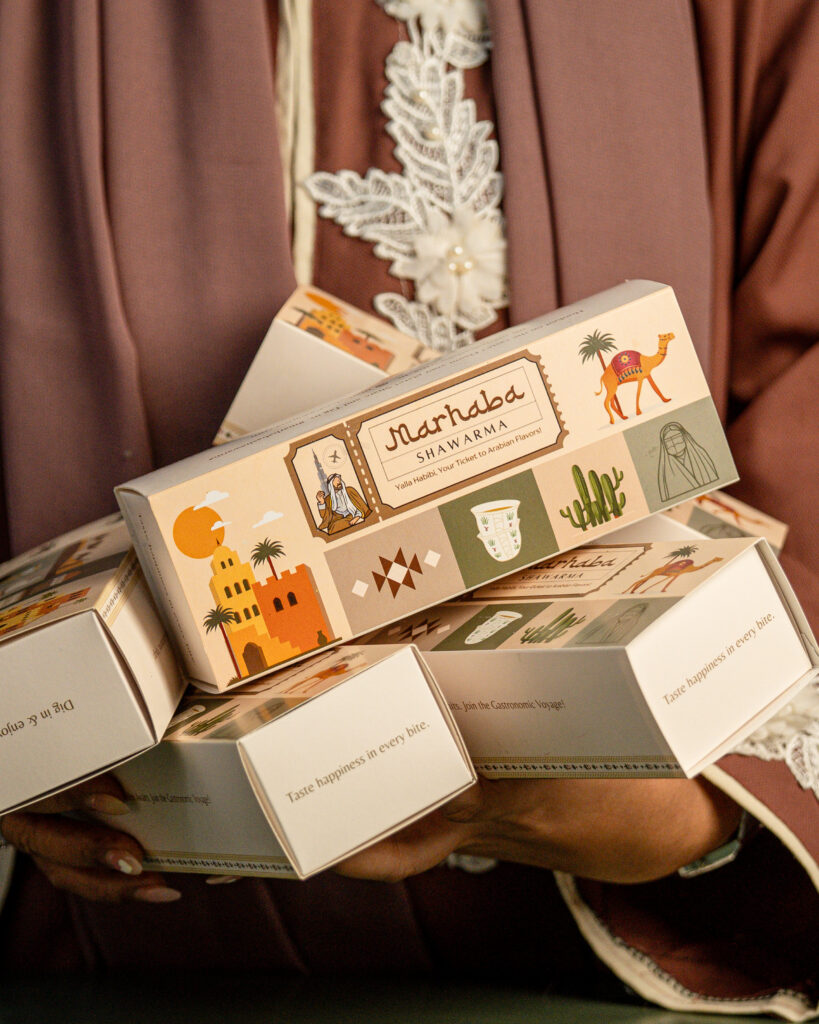 Traditional Middle Eastern soap boxes held by a person in a brown embroidered outfit.