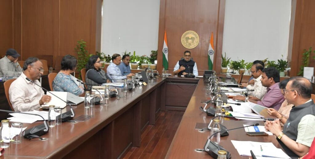 Officials and ministers seated around a large conference table during a formal government meeting in a U.